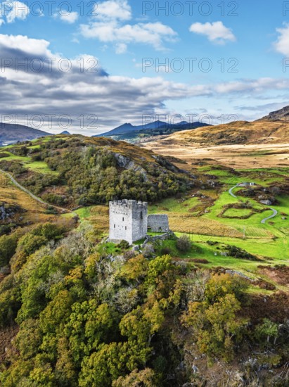 Autumn colours over Castell Dolwyddelan and Eryri Mountains from a drone, Snowdonia, Conwy County Borough, Wales, England, United Kingdom