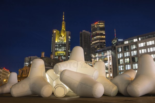 Illuminated tetrapods lie at Hauptwache in front of Frankfurt's banking skyline, Frankfurt, Hesse, Germany