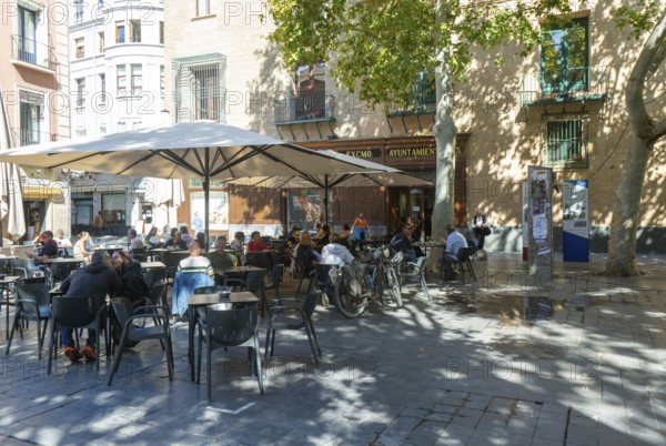 People sitting at tables and chairs in courtyard, Plaza de San Filipe, Zaragoza, Aragon, Spain