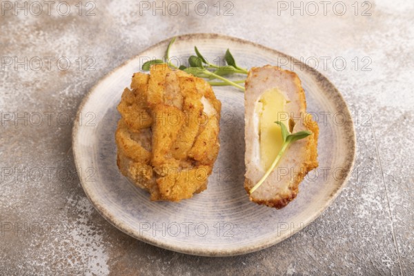 Chicken schnitzel on blue plate with microgreen on brown concrete. Diet, healthy eating. side view, close up