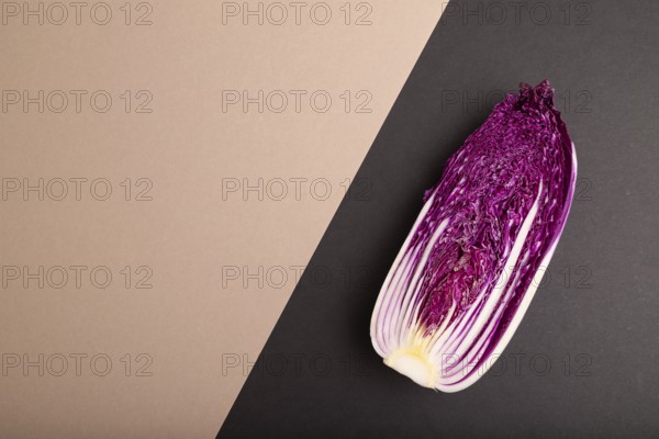 Purple Chinese cabbage on brown and black pastel paper background, top view, flat lay, copy space, minimalism
