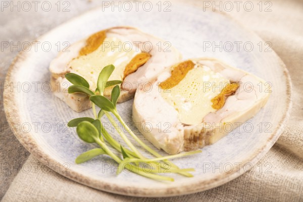 Chicken, egg and dried apricot meatloaf, microgreen on brown concrete background and linen textile. side view, close up, selective focus