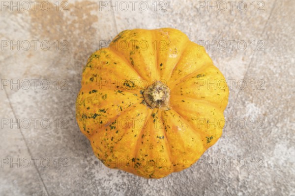 Orange Pumpkin on brown concrete background. Top view, close up, flat lay. healthy food, vegetable, minimalism