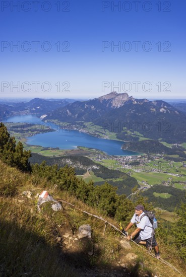 Hikers at the Iron Ladder on the way to Rettenkogel with Wolfgangsee, Postalm, Osterhorn Group, Salzkammergut, Province of Salzburg, Austria