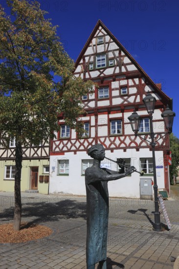 Half-timbered houses and fountain figure flute player, on Rathausplatz, city of Heideck in the district of Roth, Middle Franconia, Bavaria, Germany