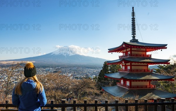 Tourist enjoying the view, five-story pagoda of a Shinto shrine, Chureito Pagoda, with views of Fujiyoshida City and Mount Fuji volcano, Arakura Fuji Sengen Shrine, Arakurayama Sengen Park, Yamanashi Prefecture, Japan