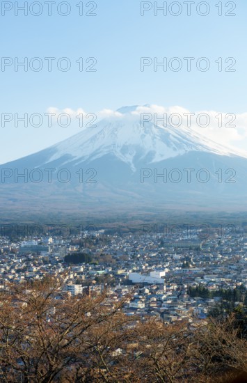 View of Mount Fuji volcano over Fujiyoshida City in the evening light, Yamanashi Prefecture, Japan