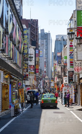 Street scene, lots of colorful signs of shops, restaurants and bars in a street, Shinjuku City, Tokyo, Japan