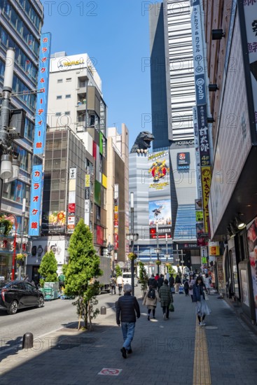 Street scene with skyscrapers, figure Godzilla head on a skyscraper, Shinjuku City, Tokyo, Japan