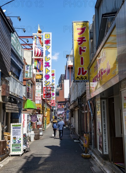 Lots of colorful signs of shops, restaurants and bars in a small alley, Shinjuku City, Tokyo, Japan