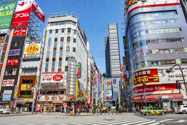 Bustling street scene in Japan with modern buildings and colorful billboards, figure of Godzilla head on a high-rise building, Shinjuku City, Tokyo, Japan