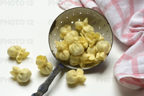 Saccottini, type of Italian pasta in a sieve ladle, pasta from Italy
