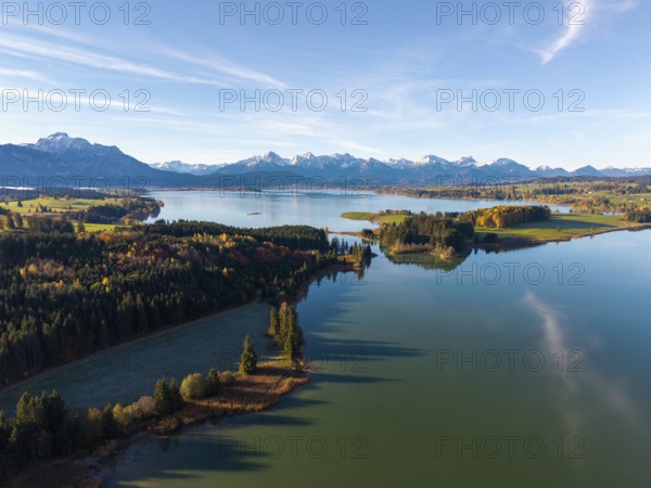 Clear reflections of a quiet lake surrounded by forests and mountains in autumn, Illasbergsee, Forggensee, near Roßhaupten, Ostallgäu, Allgäu, Swabia, Bavaria, Germany