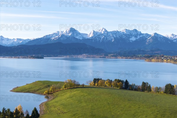 Harmonious alpine scenery with snow-capped mountain peaks, calm seas and autumnal vegetation