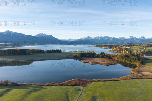 Wide landscape with lake surrounded by mountains and autumn trees under clear skies, Illasbergsee, Forggensee, near Roßhaupten, Ostallgäu, Allgäu, Swabia, Bavaria, Germany
