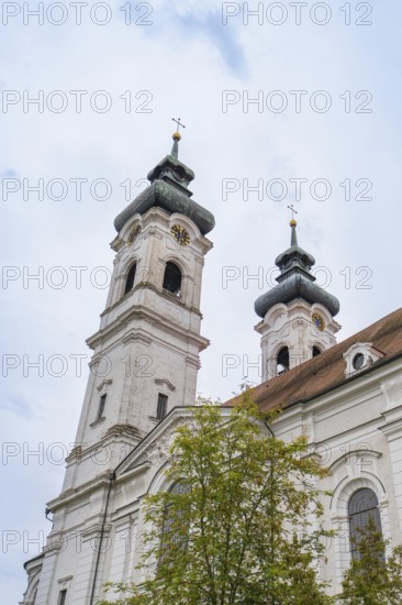 Two tall baroque church towers with crosses in the background of a cloudy sky, ZFP Zwiefalten, Reutlingen district, Germany