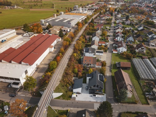Autumn village with Hermann Hesse Bahn railway line, surrounded by residential buildings, industrial buildings and trees, Althengstett, Calw district, Germany