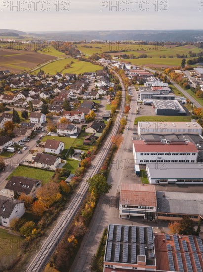 A Hermann Hesse Railway line surrounded by autumnal fields and industrial buildings in a rural area, Althengstett, Calw district, Germany