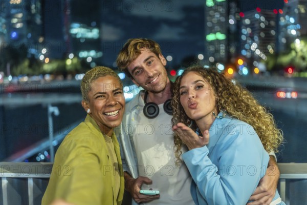 Diverse group of young adult friends enjoying a fun night out in the city, smiling and posing for a selfie against a backdrop of blurry urban lights, celebrating youth and modern friendship