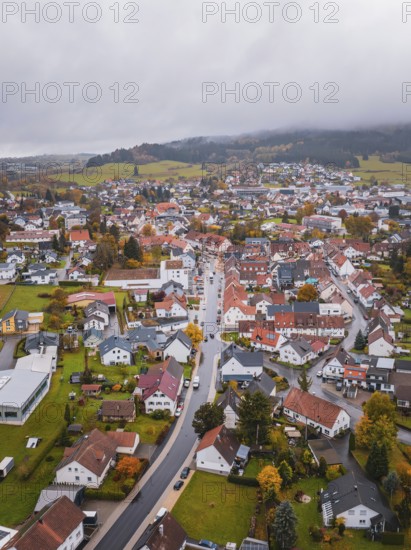 Small village, seen from above, surrounded by autumn leaves. Foggy horizon and hilly landscape, Wehingen, Tuttlingen district, Germany