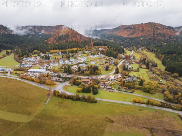 Extensive autumn landscape with a small village nestled between fog-covered hills, Wehingen, Tuttlingen district, Germany