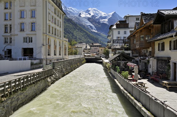 Glacier river Arve flows through the city, with the snow-capped Mont-Blanc mountain range behind, Chamonix-Mont-Blanc, Haute-Savoie, France