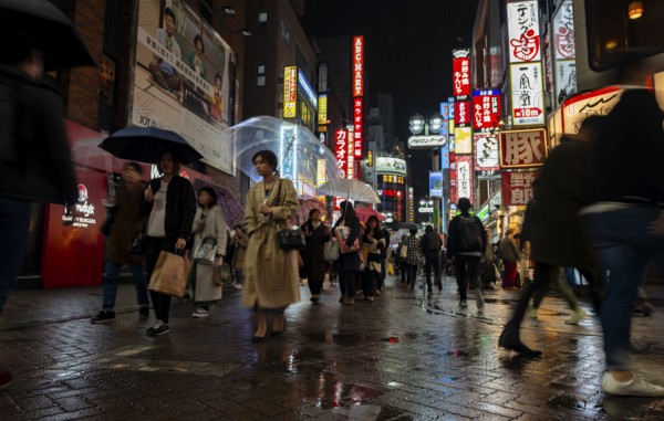 Busy pedestrian zone with many shopping centers and stores, illuminated with lots of neon signs at night, Shibuya, Udagawacho, Tokyo, Japan