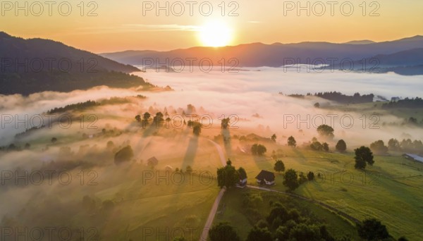Sunrise over a fog covered village in a rural landscape, golden morning light, serene autumn atmosphere, hills and mountains in the background, AI generated