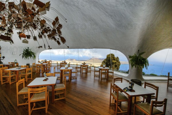 Interior of café with panoramic window in building designed by Cesar Manrique with the collaboration of Jesús Soto and architect Eduardo Caceres without right angles corners on viewpoint tourist attraction El Mirador del Río on the summit of the 474 meter high Risco de Famara in Famaramassiv with panoramic view of the Chinijo Archipelago, La Graciosa island, Lanzarote, Canary Islands, Canary Islands, Spain
