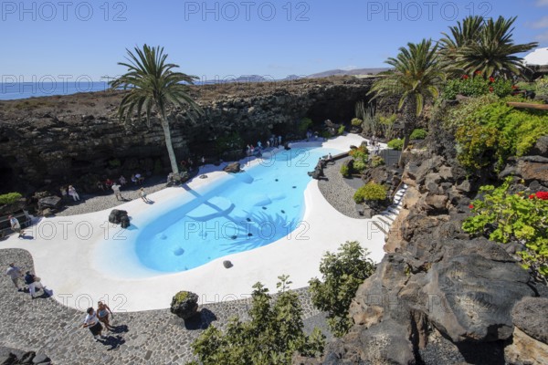 View from elevated position of pool designed by César Manrique Swimming pool in art venue cultural center tourist attraction Jameos del Agua, Punta Mujeres, Lanzarote, in the background East Atlantic, Canary Islands, Spain