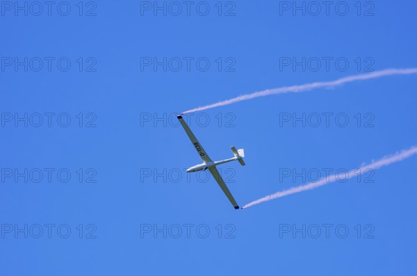 An SZD-59-1 ACRO glider, registration D-1138, during a demonstration as part of an air show at the Fliegerbergfest of the Rossfeld Luftsportverein in Metzingen-Glems, Baden-Württemberg, Germany, for editorial use only