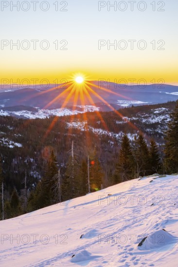 Sunrise over the hills of czech republic from Mount Lusen wth the view over the hills of the bavarian forest in winter, Bavaria, Germany