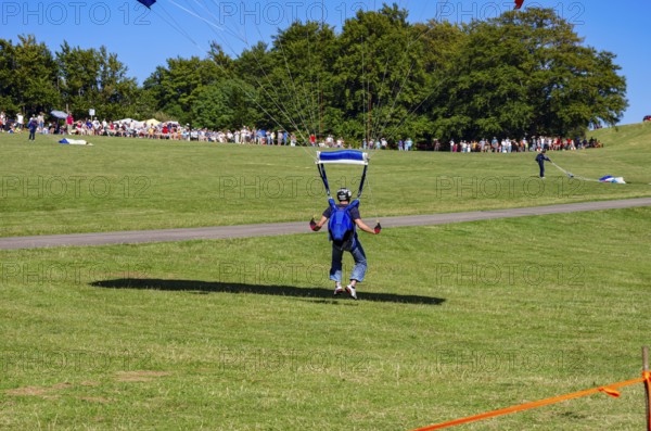 Landing of skydivers during an aerial acrobatic performance as part of an air show at the Rossfeld Air Sports Association Air Sports Festival on Rossfeld in Metzingen-Glems, Baden-Württemberg, Germany, for editorial use only