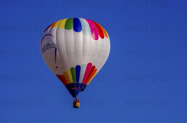 A hot air balloon, registration D-OÖJ, rises into the air as part of an air show at the Fliegerbergfest of the Rossfeld Luftsportverein in Metzingen-Glems, Baden-Württemberg, Germany, for editorial use only
