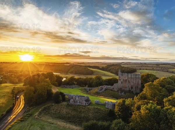 Sunset over Norham Castle and River Tweed from a drone, Norham, Northumberland, England, United Kingdom
