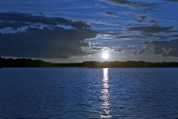 Atmospheric moonrise over Lake Gudelack, Lindow (Mark), Stechlin-Ruppiner Land nature park Park, Brandenburg, Germany