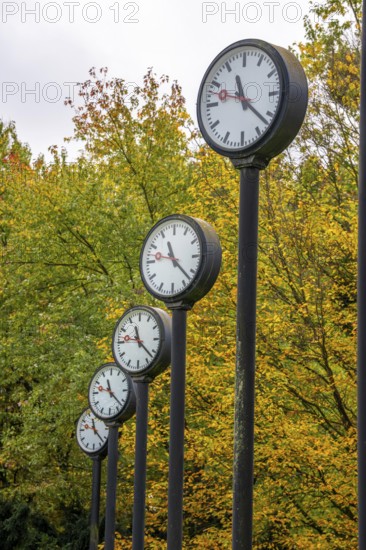 The art installation Zeitfeld in Volksgarten Park in Düsseldorf-Oberbilk, a total of 24 station clocks, on 6 meter high steel columns, have been running synchronously since 1987, artwork by Düsseldorf artist Klaus Rinke, symbol of time, time change, North Rhine-Westphalia, Germany