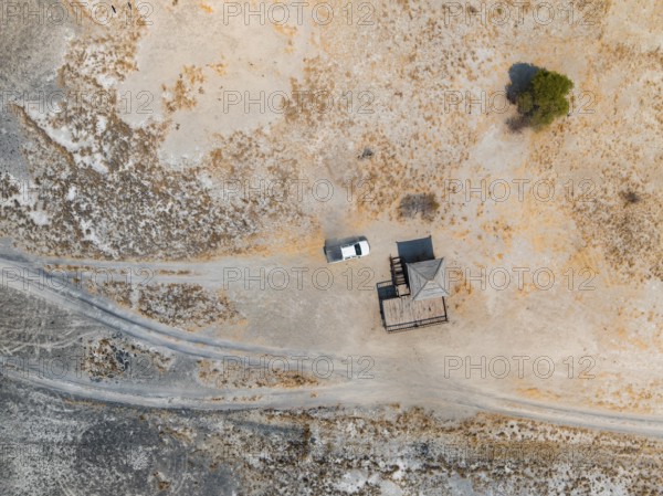 Aerial view, top-down view, off-road car driving on a salt pan, arid landscape, Botswana