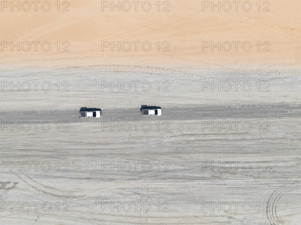 Aerial view, top-down view, two off-road cars driving on a road in arid countryside, Botswana