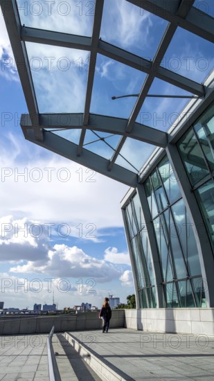 Modern architectural framework with glass and steel structure, glass facade with a greed of steel arrows, blue sky with a soft golden light of a sunrise, AI generated