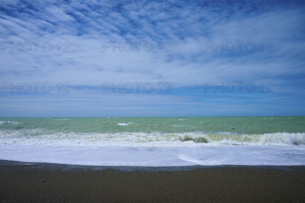 Wavy beach with calm sky in the background, Tuhawaiki Point Lighthouse or Jack's Point Lighthouse, Scarborough, Timaru, South Island, New Zealand