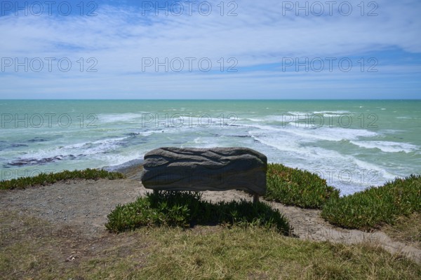 Wooden bench with sea view under cloudy sky, Tuhawaiki Point Lighthouse or Jack's Point Lighthouse, Scarborough, Timaru, South Island, New Zealand