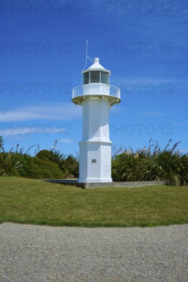 White lighthouse in a meadow next to the coast, Tuhawaiki Point Lighthouse or Jack's Point Lighthouse, Scarborough, Timaru, South Island, New Zealand