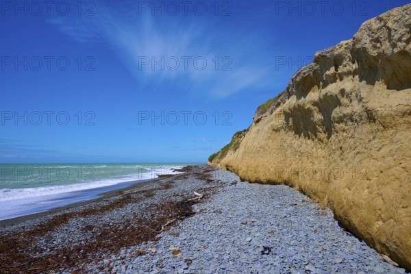 Cliff with pebble beach and blue sky on a sunny day, Tuhawaiki Point Lighthouse or Jack's Point Lighthouse, Scarborough, Timaru, South Island, New Zealand