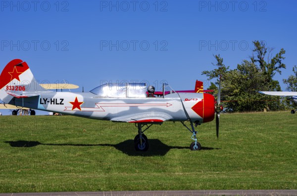 A Jakovlev Jak-52 with registration LY-HLZ during a flight demonstration as part of an air show on Rossfeld in Metzingen-Glems, Baden-Württemberg, Germany, for editorial use only