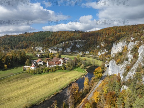 Aerial view of Käppeler Manor with St. George's Basilica near Thiergarten in the Upper Danube Valley, surrounded by autumn vegetation, on the right the raven rocks, climbing rocks, Jura limestone rocks, Sigmaringen district, Baden-Württemberg, Germany