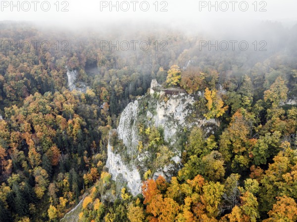 Aerial view of the viewpoint, shovels and Hausen Castle, also known as the Hausen ruins, surrounded by autumnal vegetation and clouds of fog, a ruin of a castle above the village of Hausen in the valley in the Upper Danube Valley, Beuron, Sigmaringen district, Baden-Württemberg, Germany