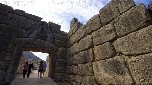 Group of visitors pass through a huge stone gate, lion gate, Mycenae, archaeological site, UNESCO World Heritage Site, Mycenae, Mycenae, important city in pre-classical times, Peloponnese, peninsula, Greece