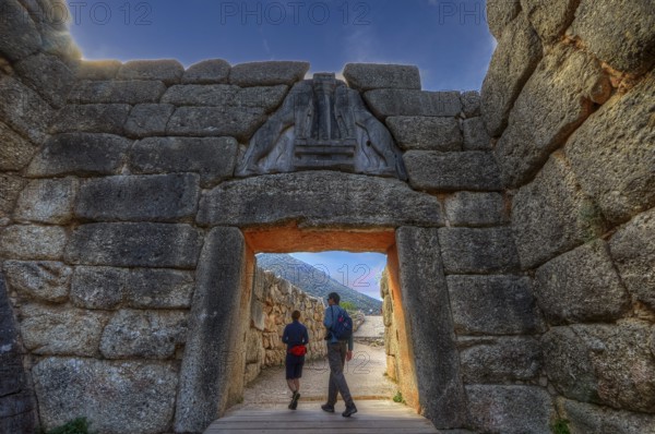 HDR, sky changed, couple walking through a huge stone gate, lion gate, Mycenae, archaeological site, UNESCO World Heritage Site, Mycenae, Mycenae, important city in pre-classical times, Peloponnese, peninsula, Greece