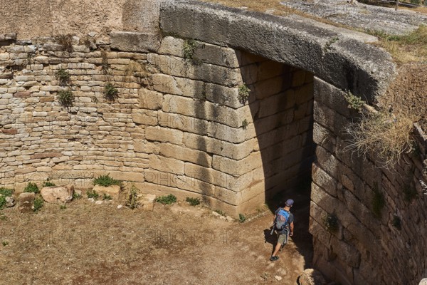 Visitor walks through huge stone gate, Mycenaean domed tomb, archaeological site, UNESCO World Heritage Site, Mycenae, Mycenae, important city in pre-classical times, Peloponnese, peninsula, Greece